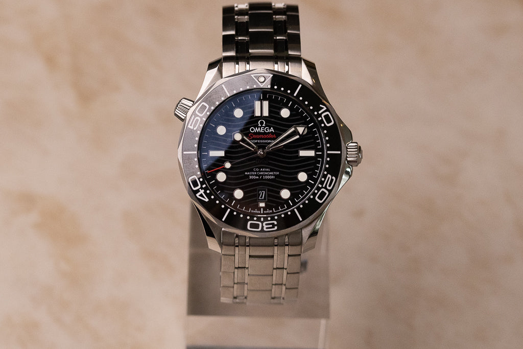 Omega Seamaster Diver 300M ref. 210.30.42.20.01.001 — zwarte keramische wijzerplaat met golfpatroon op stalen band, vooraanzicht