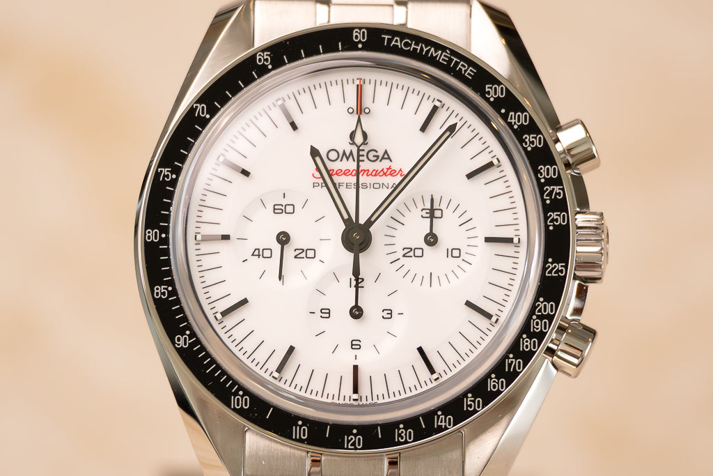 Omega Speedmaster Moonwatch White ref. 310.30.42.50.04.001 — detail witte wijzerplaat met rode Speedmaster-tekst en drie subdials