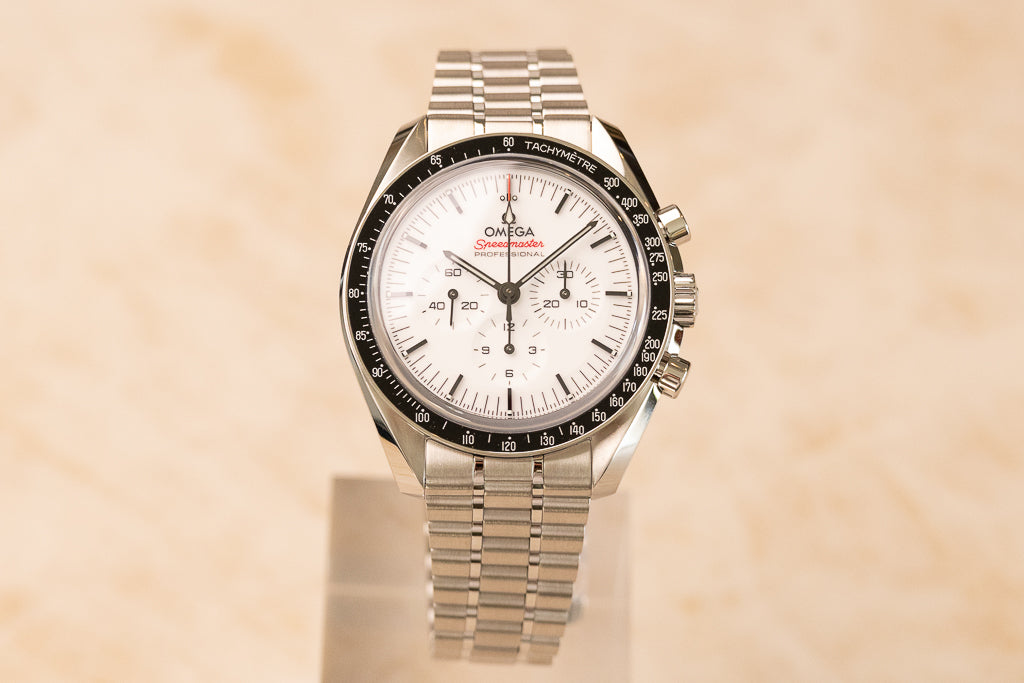 Omega Speedmaster Moonwatch White ref. 310.30.42.50.04.001 — witte gelakte wijzerplaat met zwarte tachymeterlunette, vooraanzicht