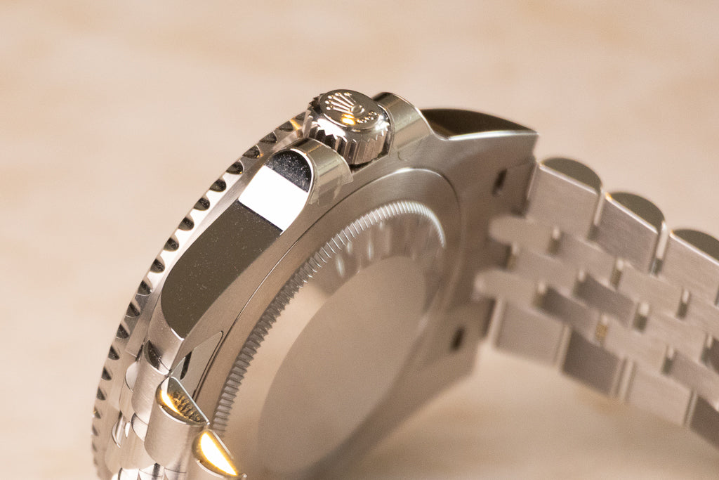 Rolex GMT-Master II Bruce Wayne ref. 126710GRNR — zijaanzicht met Oystersteel kast en Triplock-kroon close up
